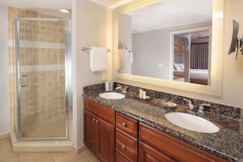 オーランドにあるHilton Grand Vacations Club Tuscany Village Orlandoのバスルーム(シンク2台、シャワー付)