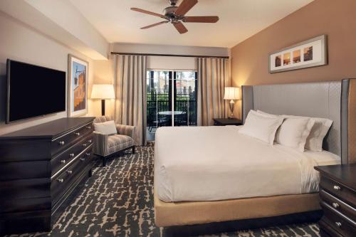 a bedroom with a bed and a flat screen tv at Hilton Grand Vacations Club Tuscany Village Orlando in Orlando