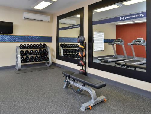 a gym with mirrors and a bench and weights at Hampton Inn Ottumwa in Ottumwa