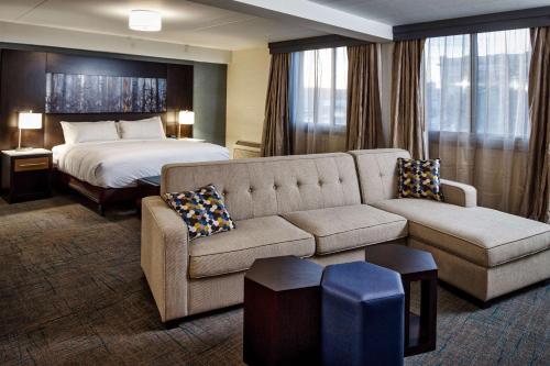 une chambre d'hôtel avec un canapé et un lit dans l'établissement DoubleTree by Hilton Neenah, à Neenah