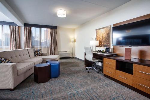 a hotel room with a couch and a desk at DoubleTree by Hilton Neenah in Neenah