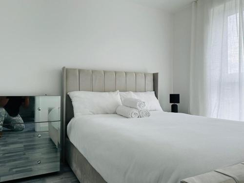 1 dormitorio con 1 cama blanca grande y espejo en Stylish new built double bed, en Mánchester