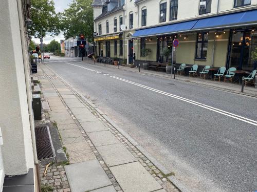 an empty street with chairs on the side of the road at Central Lyngby Apartments in Kongens Lyngby