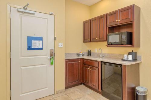 a kitchen with wooden cabinets and a white door at Hampton Inn Owensboro in Owensboro