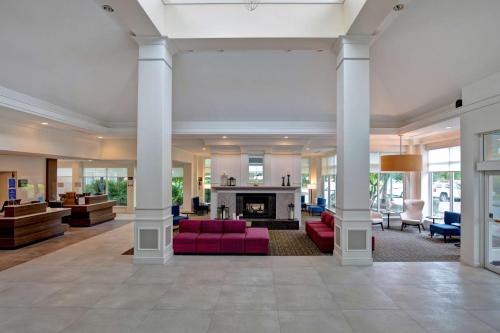 a lobby with white columns and a fireplace at Hilton Garden Inn Portland/Beaverton in Beaverton