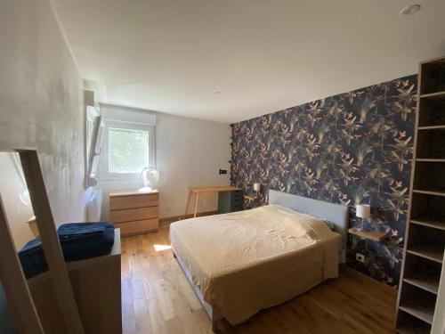 une chambre avec un lit et une peinture murale dans l'établissement Appartement calme et lumineux proche de Lyon, à Saint-Romain-au-Mont-dʼOr