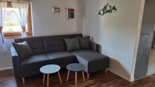 a living room with a couch and two tables at Ferienwohnung Bergfreunde inkl Chiemgaukarte in Bergen