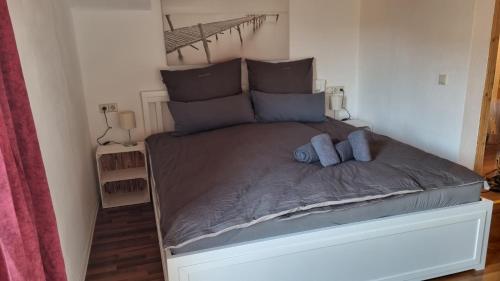 a bed with two blue pillows on top of it at Ferienwohnung Bergfreunde inkl Chiemgaukarte in Bergen