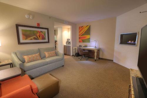 a living room with a couch and a desk at Hilton Garden Inn Pigeon Forge in Pigeon Forge