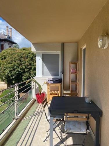 d'un balcon avec une table et des chaises noires. dans l'établissement Appartement calme et lumineux proche de Lyon, à Saint-Romain-au-Mont-dʼOr