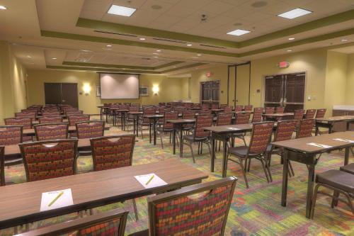 a conference room with tables and chairs and a screen at Hilton Garden Inn Pigeon Forge in Pigeon Forge