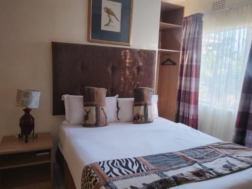a bedroom with a bed and a window at Ecotel OR Tambo Airport in Kempton Park