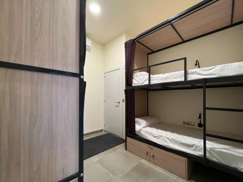 Cette chambre comprend 2 lits superposés et une porte. dans l'établissement Multi Hostel Calvario, à Madrid