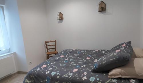 a bed with a black comforter with flowers on it at Les gîtes de Camarel in La Plaine