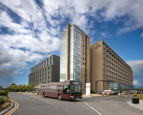 un autobús estacionado en un estacionamiento frente a un edificio en Clayton Hotel Dublin Airport en Cloghran