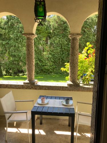 uma mesa e cadeiras em uma sala com janela em B&B Villa Cortese em Clusone