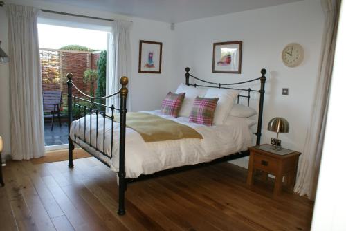 a bedroom with a bed and a window and a table at Keeper's Lodge in Rowlands Castle