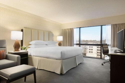 a hotel room with a bed and a large window at Hilton Greenville in Greenville