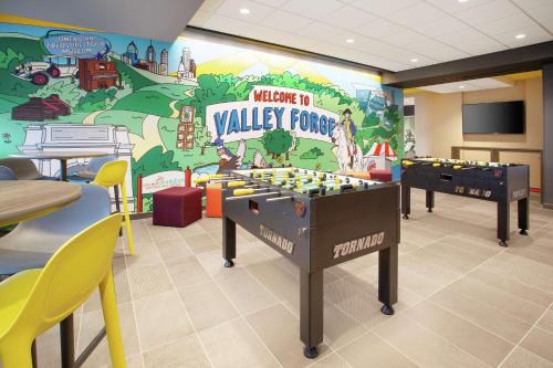 a childrens play room with two foosball tables in front of a wall at Tru By Hilton Audubon Valley Forge in Audubon