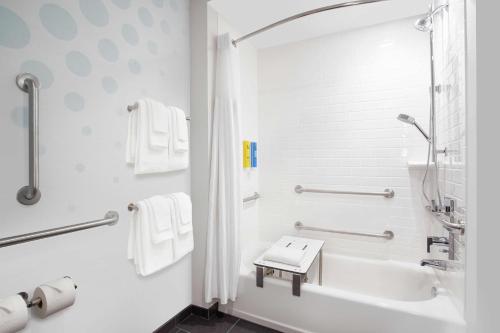Baño blanco con bañera y lavamanos en Tru By Hilton Audubon Valley Forge, en Audubon