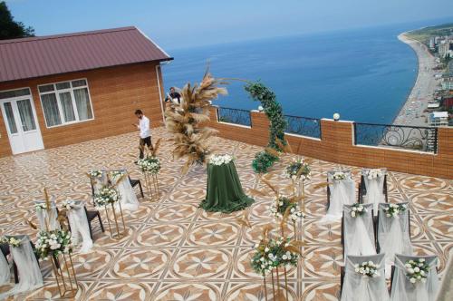 una mesa y sillas en un balcón con vistas al océano en Goga Guest House, en Kvariati