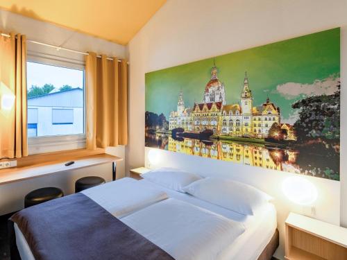 a bedroom with a bed and a painting on the wall at B&B Hotel Hannover-Nord in Hannover