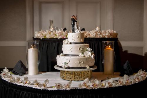 a wedding cake sitting on top of a table with candles at DoubleTree by Hilton Philadelphia Airport in Philadelphia