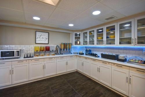 a large kitchen with white cabinets and a microwave at Homewood Suites by Hilton Philadelphia-Great Valley in Malvern