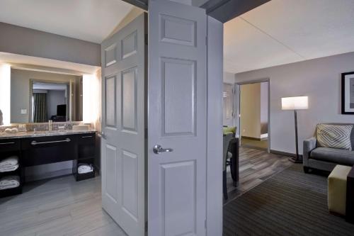 a room with a bathroom with a sink and a door at Homewood Suites by Hilton Philadelphia-Great Valley in Malvern