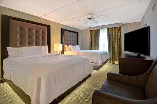 a hotel room with two beds and a flat screen tv at Homewood Suites by Hilton Philadelphia-Great Valley in Malvern