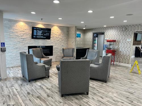 a waiting room with chairs and a fireplace at Clarion Pointe - Greensboro Coliseum Area in Greensboro
