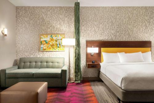 a hotel room with a bed and a couch at Home2 Suites By Hilton Ridley Park Philadelphia Airport So in Ridley Park
