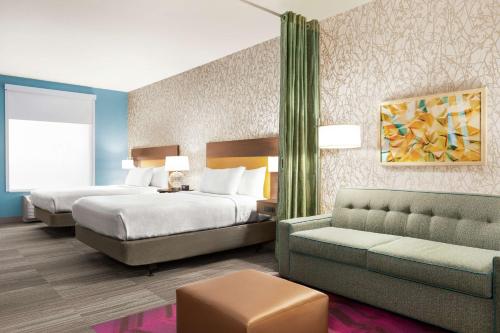 Home2 Suites By Hilton Ridley Park Philadelphia Airport So في Ridley Park: غرفة فندقية بسريرين واريكة