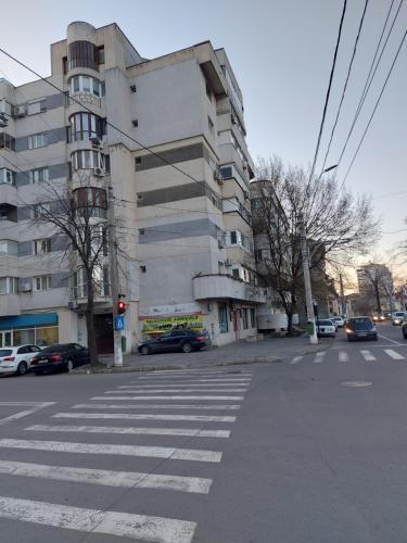 an empty street with a building and a crosswalk at Cuza 21 in Brăila