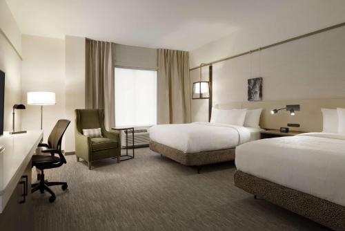 a hotel room with two beds and a desk at Hilton Garden Inn Newtown Square Radnor in Newtown Square