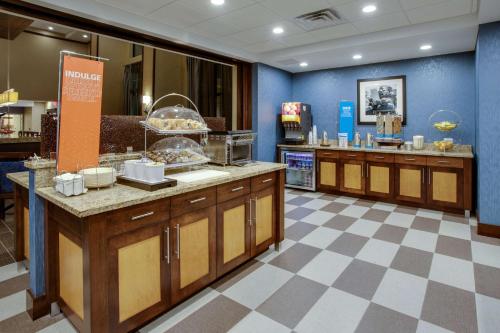 a restaurant kitchen with a counter with food at Hampton Inn & Suites Philadelphia/Bensalem in Bensalem