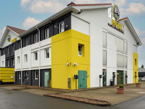 een geel en wit gebouw met een bord erop bij B&B Hotel Hannover-Nord in Hannover