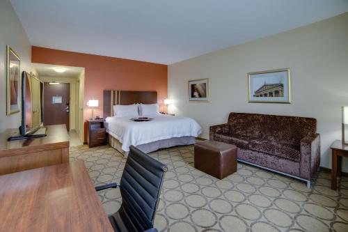 a hotel room with a bed and a couch at Hampton Inn & Suites Philadelphia/Bensalem in Bensalem