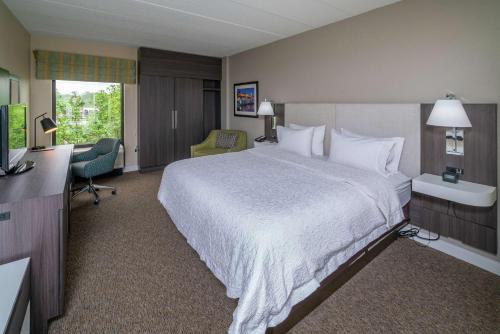 a hotel room with a large bed and a desk at Hampton Inn & Suites Valley Forge/Oaks in Phoenixville