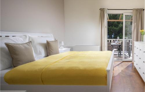 a large yellow bed in a white room with a window at Villa 10 Mala Rudina in Rudina