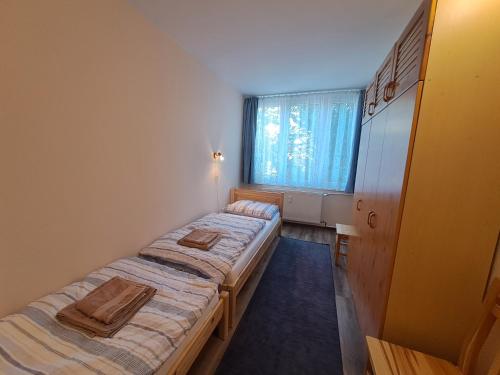 2 camas en una habitación pequeña con ventana en Kaptár lakás en Komárom