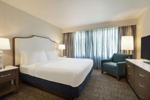 a hotel room with a bed and a chair at Embassy Suites by Hilton Philadelphia Valley Forge in Wayne