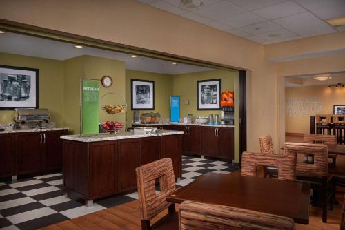 a restaurant with a counter and tables and chairs at Hampton Inn Phoenix/Anthem in Anthem
