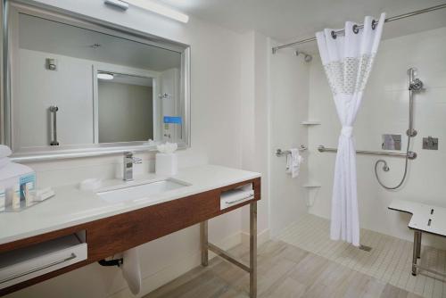 ein Bad mit einem Waschbecken, einem Spiegel und einer Dusche in der Unterkunft Hampton Inn Phoenix/Anthem in Anthem