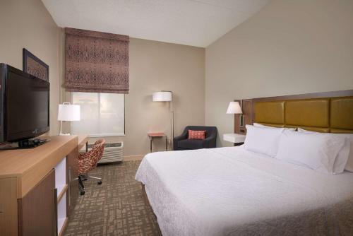 a hotel room with a bed and a flat screen tv at Hampton Inn Phoenix/Anthem in Anthem