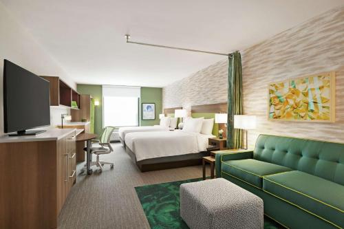 a hotel room with a bed and a couch at Home2 Suites By Hilton Scottsdale Salt River in Scottsdale