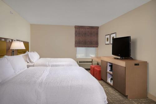 a hotel room with two beds and a flat screen tv at Hampton Inn Phoenix/Anthem in Anthem