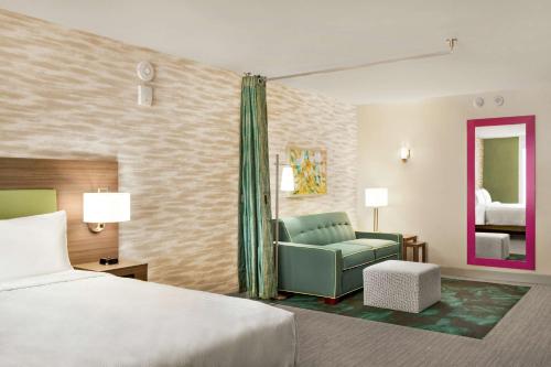 a hotel room with a bed and a chair at Home2 Suites By Hilton Scottsdale Salt River in Scottsdale