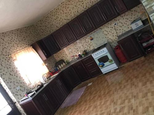 a kitchen with wooden cabinets and a counter top at Your cozy apartment in Al-Karak in Kerak