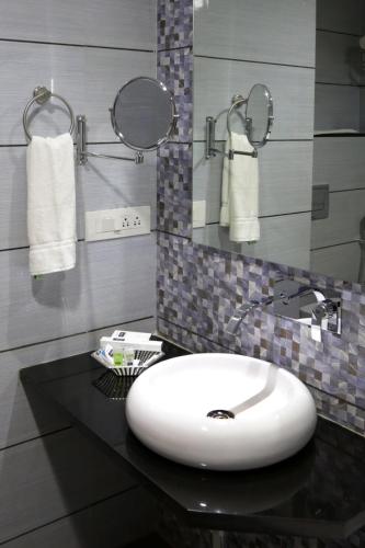 a bathroom with a sink and towels on a counter at Grand Kailash Hotel in Aurangabad